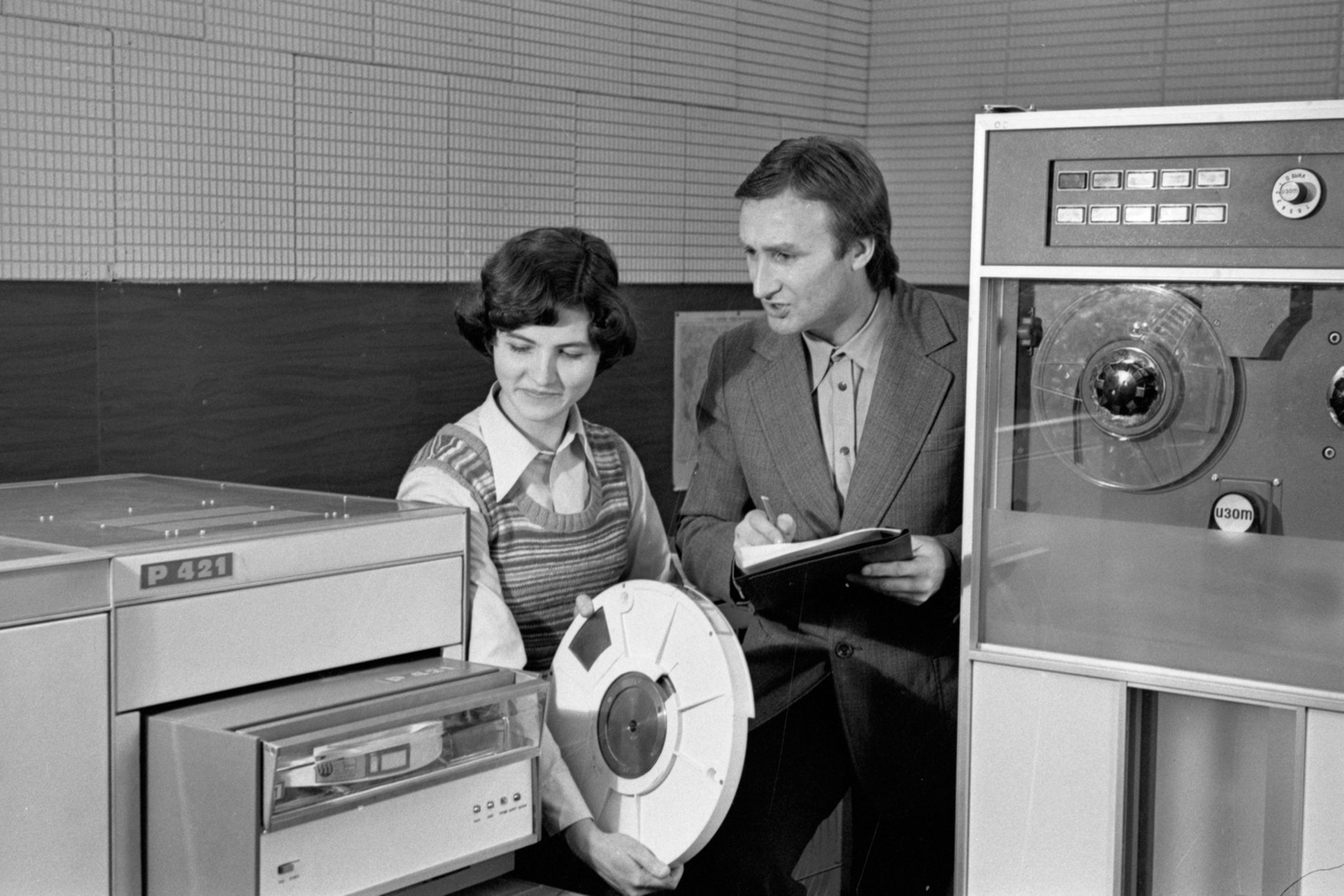 Panevėžio tiksliosios mechanikos gamyklos inžinierė programuotoja F. Petravičienė ir elektroninių skaičiavimo mašinų viršininkas A. Purtulis tikrina modernizuotos magnetinės atminties įrenginio AR-421 darbą. 1978 m. gruodžio 20 d. A. Dilio nuotrauka. Liet